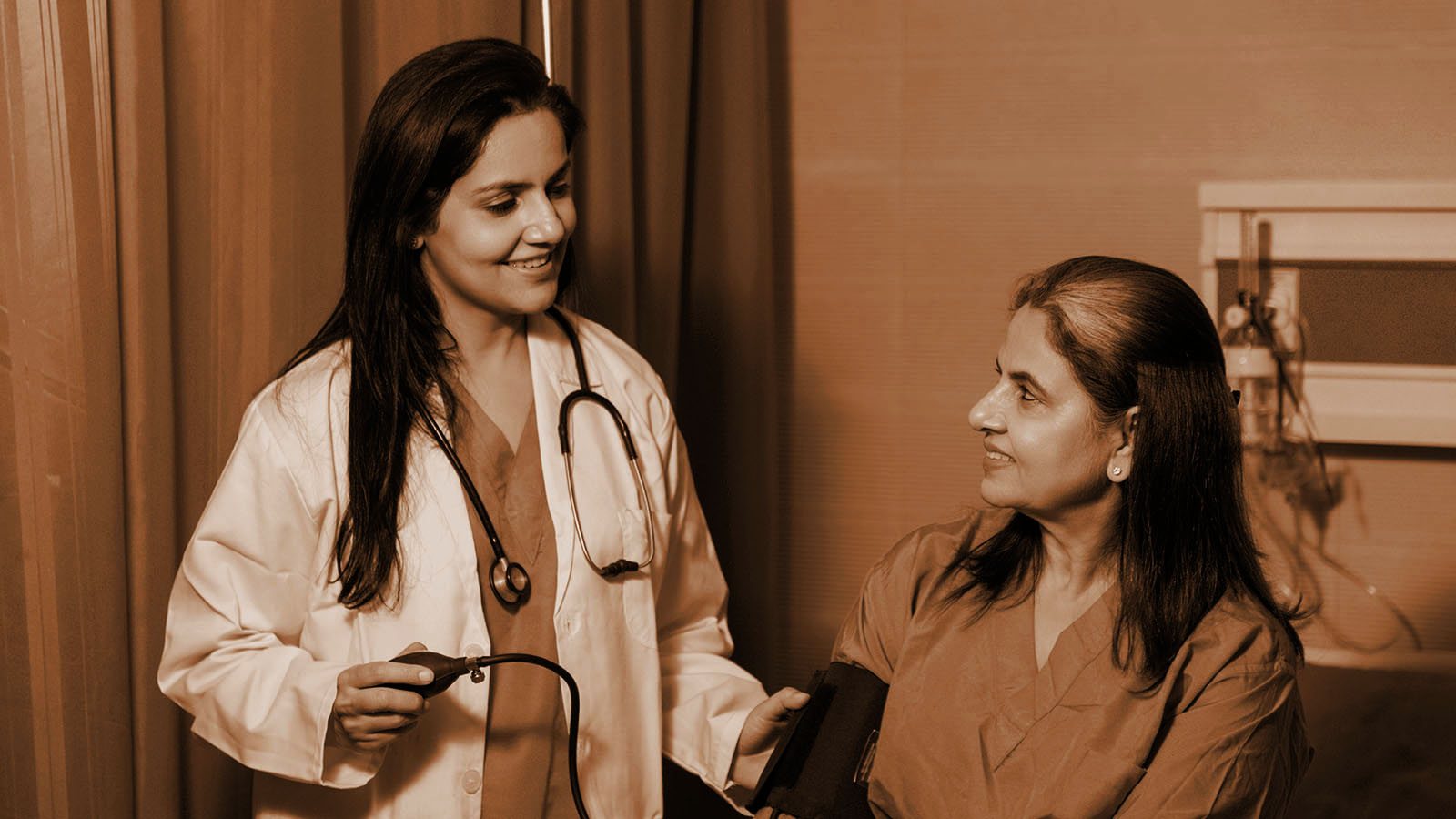 Hospital ward nurse monitoring patient bed